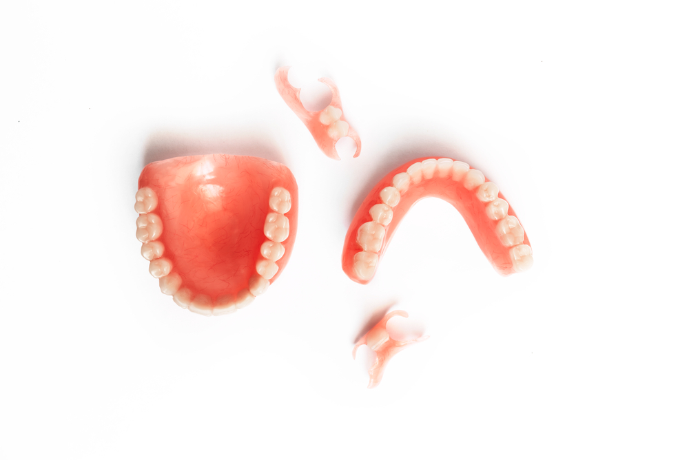 Dentures on a white background. Close-up of dentures. Full removable plastic denture of the jaws. Prosthetic dentistry. False teeth. Close-up of plastic dentures. Teeth on a white background